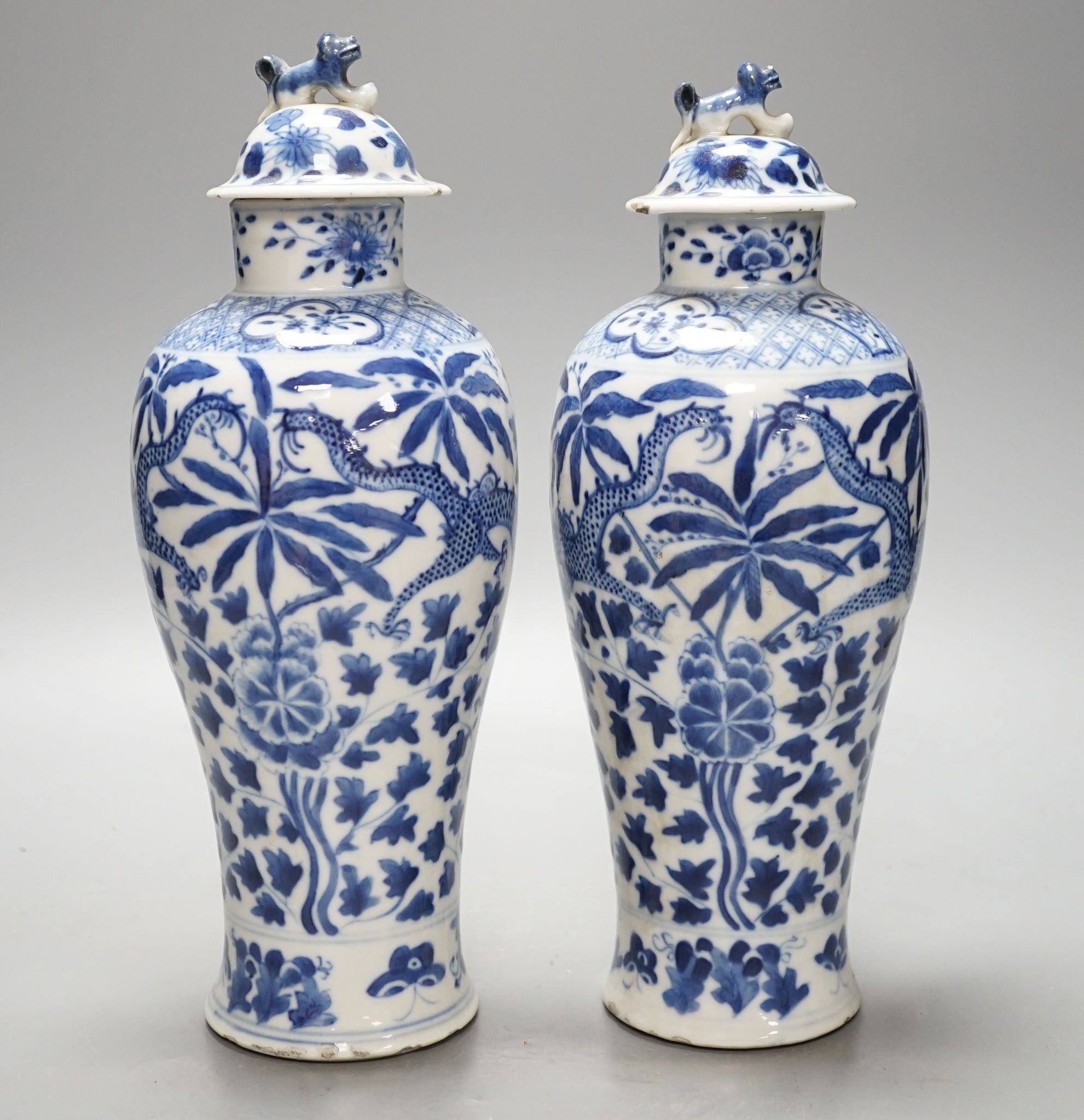 A pair of Chinese blue and white dragon vases and covers, circa 1900. 28cm